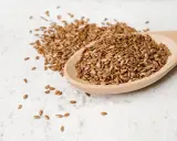 Łyżka pełna siemienia lnianego, idealnego dla zdrowia psa. Te małe nasionka to bogactwo kwasów omega-3.
